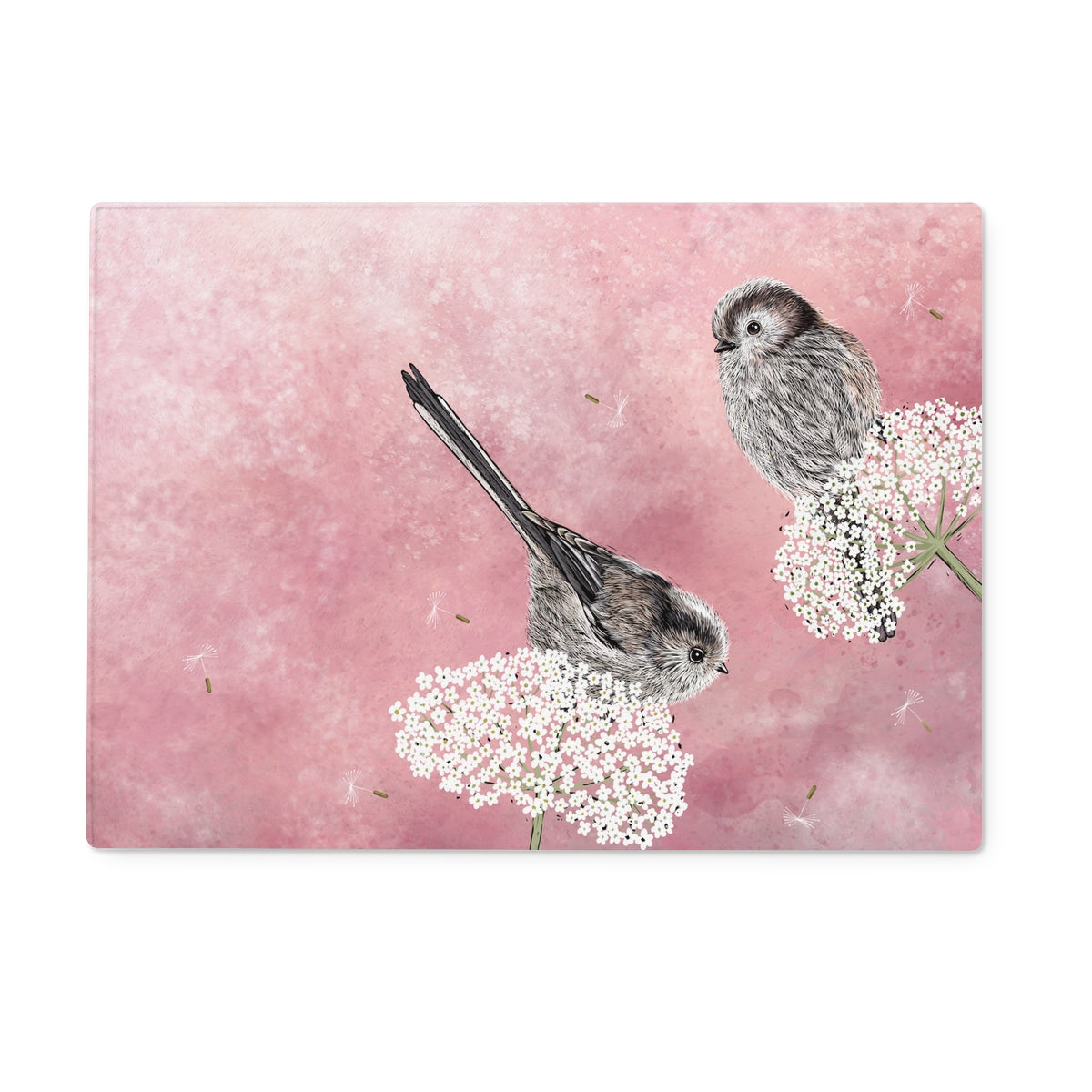 This glass chopping board design from Fox and Boo depicts two cute long tailed tits balancing on some cow parsley, background is a watercolour berry pink, with floating dandelion puffs.